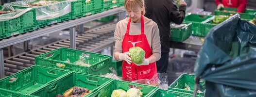Freiwillige im Einsatz am Logistik-Standort Staufen der Hilfsorganisation Tischlein deck dich stellen gerettete Lebensmittel für die Lebensmittelabgabe zusammen. 