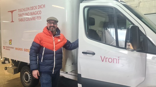 Freiwilliger Fahrer der karitativen Foodsave-Organisation Tischlein deck dich vor einem Transportfahrzeug, mit dem gerettete Lebensmittel zu armutsbetroffenen Menschen gebracht werden.