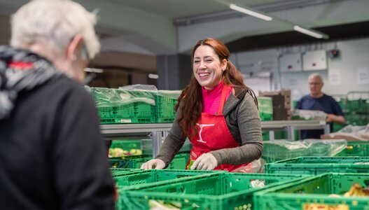 Freiwillige Helferin der Hilfsorganisation Tischlein deck dich bereitet in der Rüsterei Staufen gespendete Lebensmittel für die Lebensmittelabgabe an Armutsbetroffene Menschen vor.