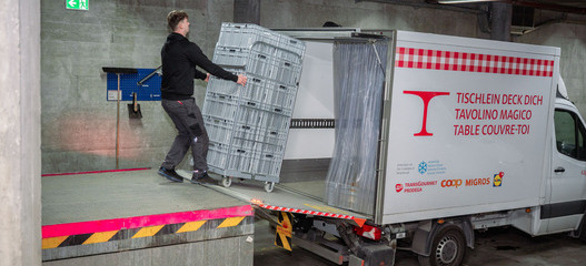 Angestellte Fachperson der Hilfsorganisation Tischlein deck dich lädt Paletten mit gespendeten Lebensmitteln aus einem Foodsave-Fahrzeug ins Logistiklager Winterthur.