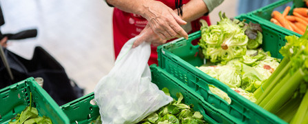 Freiwillige Helferin verpackt an einer Abgabestelle der Hilfsorganisation Tischlein deck dich gerettete Lebensmittel für armutsbetroffene Menschen in der Schweiz.