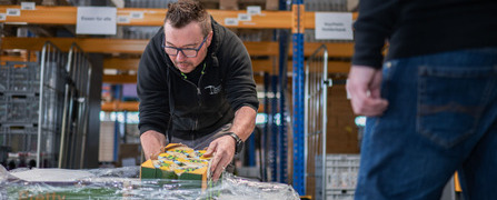 Logistikmitarbeiter der Hilfsorganisation Tischlein deck dich entnimmt eine Palette mit gespendeten Lebensmitteln sorgfältig aus der Umverpackung und hilft mit, überschüssige Lebensmittel zu retten.