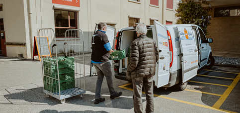 Freiwillige beladen ein Fahrzeug am Logistikstandort Penthalaz der Hilfsorganisation Tischlein deck dich mit gespendeten Lebensmitteln. 