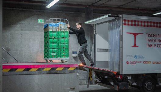 Mitarbeiter der Hilfsorganisation Tischlein deck dich lädt Paletten mit gespendeten Lebensmitteln aus einem Fahrzeug ins Logistiklager Winterthur, wo die Produkte für den Versand an eine Abgabestelle vorbereitet werden.